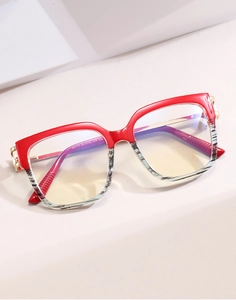 Detail of red and tiger-pattern cat-eye frame glasses with golden metal hinges