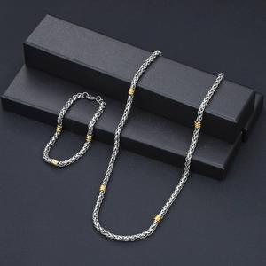 Set collana e bracciale in acciaio inox argento con accenti in oro su scatole nere