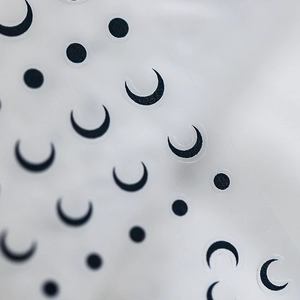 Minimalistische Nageltattoos mit schwarzen Halbmonden und Punkten auf transparenter Folie