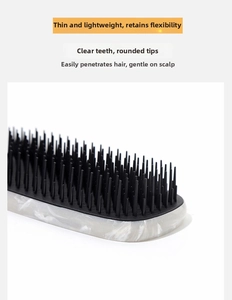 Detail of detangling comb with flexible bristles and a stylish marble texture handle