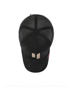 Detail of black camo baseball cap with mesh back, gold embroidery and red label side