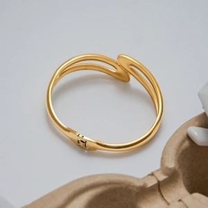 Detail of 18K gold double-layer stainless steel spring cuff with sleek polished finish