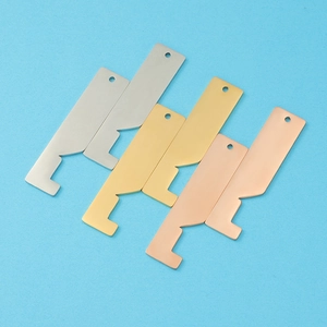 Polished stainless steel house pendants in silver, gold, and rose gold on blue background