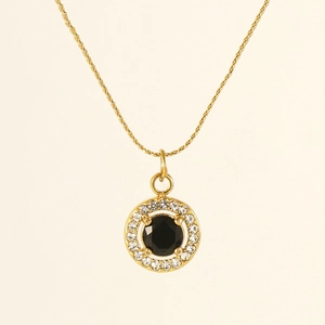 Detailed close-up of 18K gold circular necklace with black gemstone and zircon halo