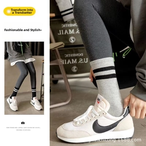 Detailed close-up of gray cotton crew socks with double stripes and white sneakers