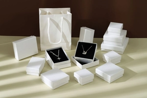 Detailed macro view of white textured paper jewelry boxes and matching gift bags