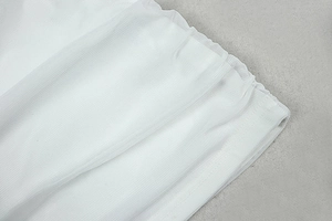 Detail of layered white mesh fabric with delicate ruffles and translucent tulle texture