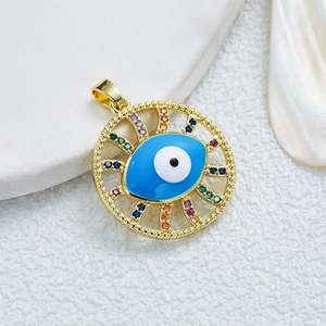 Gold plated evil eye pendant with colorful zircon stones on textured white surface