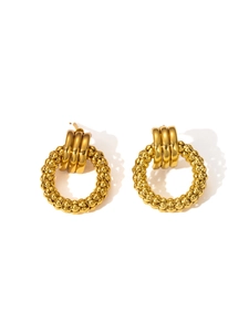 Detailed macro view of gold-plated chunky hoop earrings with textured beaded surface