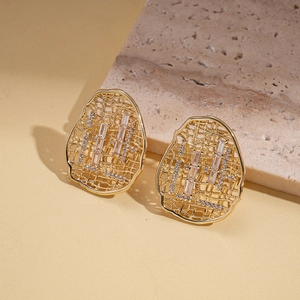 Detail of 18k gold plated hollow oval earrings with rectangular zircon and mesh texture