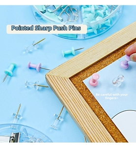 Macro view of sharp colorful push pins with plastic heads on a corkboard surface