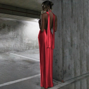 Détail d'une robe maxi rouge dos nu licou en tissu soyeux avec de longs rubans élégants