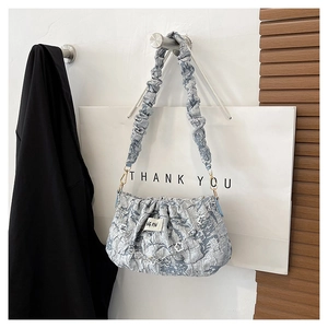 Detail of blue pleated cloud bag featuring textured bubble fabric and 3D floral accents