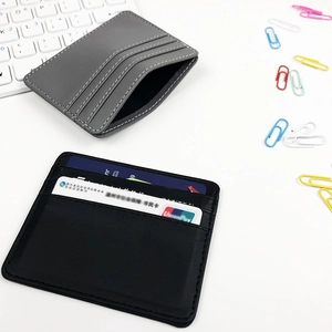 Slim minimalist leather card holder with multiple slots in black and grey office setting
