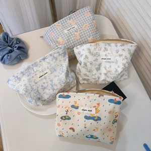 Blue aesthetic cotton cosmetic bags with cartoon bear and floral patterns on table