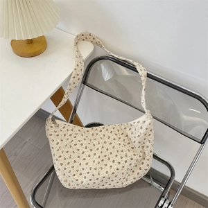 Detail of floral canvas tote bag with red flower prints on a minimalist chair