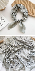 Close-up of silk-like paisley square scarf in soft sage green with floral texture