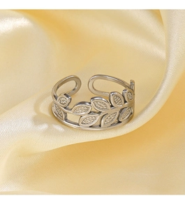 Macro shot of silver adjustable leaf ring with textured details on yellow satin fabric