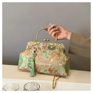 Detail of vintage evening bag with green brocade, gold clasp, and silk tassel
