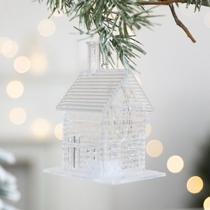 Décoration de Noël en forme de maison lumineuse transparente sur sapin avec lumières bokeh