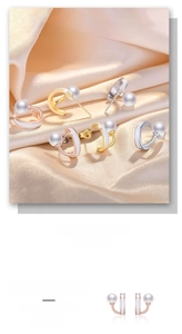 Macro detail of C-shaped pearl earrings in gold, silver, and rose gold finish