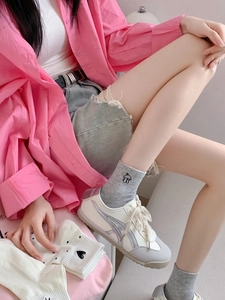 Detail of grey crew socks with cute dog embroidery paired with casual sneakers