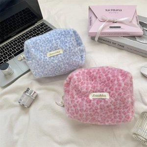 Fuzzy leopard print plush cosmetic bags in pink and blue with a convenient side handle