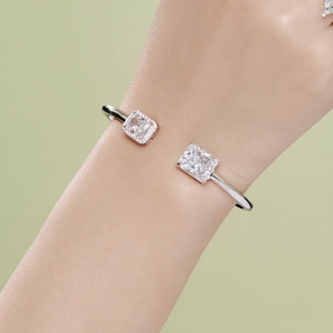 Detailed close-up of a silver spring bangle featuring two sparkling square zircon stones