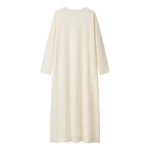 Dettaglio in piano dell'abito lungo in maglia bianco crema con drappeggio elegante e sobrio