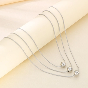 Three-layer silver snake chain necklace with metallic bead pendants in stainless steel