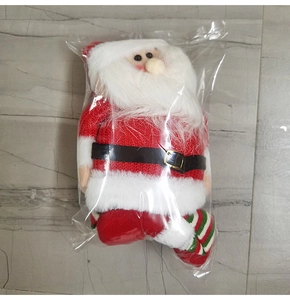 Détail d'une peluche Père Noël avec pull en tricot rouge et jambes rayées en sachet