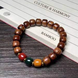 Polished black rosewood bead bracelet with colorful accents on vintage calligraphy background