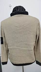 Dettaglio del retro del maglione in maglia con collo a sciarpa a contrasto e tessuto beige
