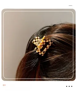 Detail of checkered square hair claw clip on back of hair for elegant styling