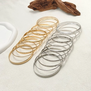 Detail of bohemian gold and silver alloy bangle set featuring textured and geometric designs