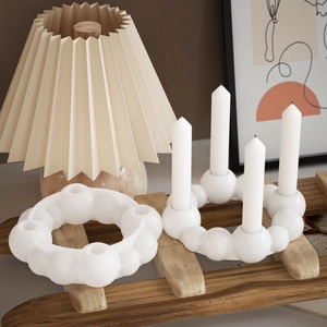 Minimalist white circular candle holder with four slots in a cozy home interior setting