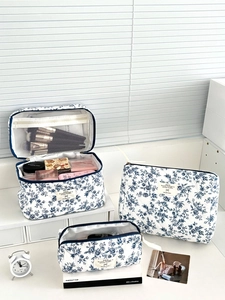 Détail de trois trousses de maquillage en coton matelassé avec motifs bleu marine