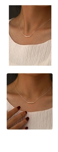 Detail of S925 silver beaded necklace with five white pearls on model neckline