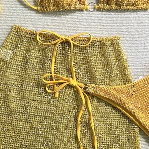 Detail of yellow glitter mesh bikini set featuring metallic rings and fine mesh texture