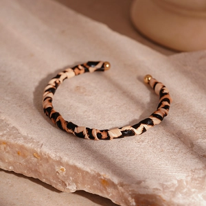 Detail of leopard print double-layer open cuff bracelet with gold metal spherical tips