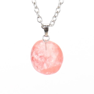 Detail of an irregular natural pink crystal stone pendant on a silver metal chain