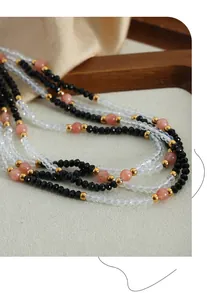 Detailed macro view of multi-layer beaded necklace with black stones and gold accents