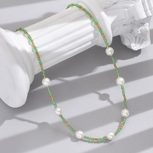 Detail of bohemian woven green and gold beads with white pearls on a roman column