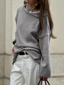 Detail of grey knitted hoodie showing loose fit texture and ribbed cuffs for women