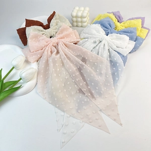 Detail of elegant chiffon bow hair clips with textured polka dots in various pastel colors