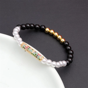 Detail of colorful zircon pave bar bracelet with black and white beads on ceramic stand