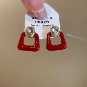 Macro detail of red square zircon earrings with silver posts and shiny crystal inlay