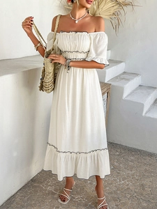 Detail view of white off-shoulder bohemian dress with black contrast wavy trim
