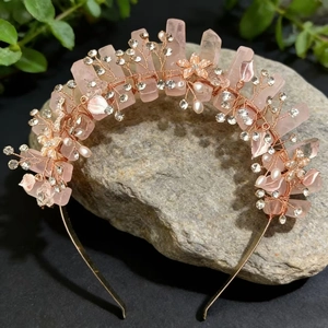 Macro detail of natural pink quartz crown with golden wire flowers and rhinestones