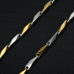 Macro view of two-tone 18k gold and silver stainless steel rhombic link chain necklace